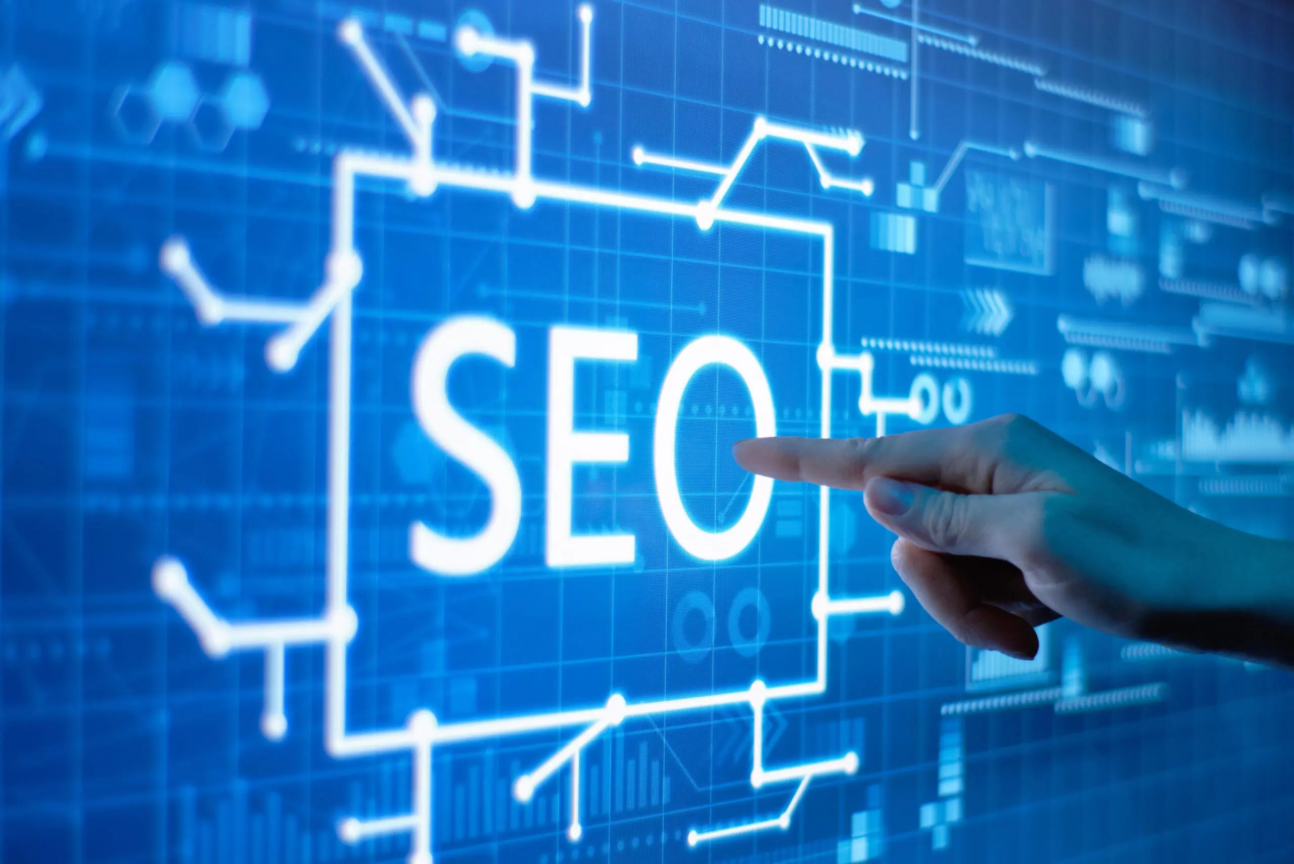 A finger pressing a white digital button of SEO.